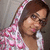 A person with brown hair and glasses wears a pink-and-white patterned hoodie, shown in three sequential poses against a gray background.