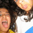 Two people with curly hair appear in a pixelated image; one sticks out their tongue while the other has their mouth open, set against bright pink and gray backgrounds.