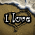 A beach scene with a heart-shaped sand drawing containing text that changes across frames.