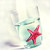 A pixelated static image shows a red starfish on a light blue and white background with faint green accents.