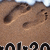 Brown textured surface with dark brown irregular patches and a light beige curved line, bottom edge shows partial black and white pixelated text.