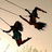 Two figures on swings against a light background with subtle grassy elements, one figure in dark clothing with green accents, the other in dark clothing with red accents.
