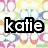 Pixelated text 'katie' in bold black and white lettering against a blurred pastel background with pink, yellow, and blue tones.
