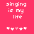 Pixelated text 'singing is my life' on bright pink background with five heart symbols below, two versions differ in heart color sequence.