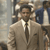 Static 50x50 pixel icon depicting a man in a light-colored suit and dark tie with a hat, partially obscured by pixelation against an indistinct background.
