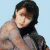 A pixelated image of a person with dark hair and light skin wearing a gray top, positioned next to green text on a dark background.