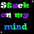 Pixelated text 'Stuck on my mind' in green, purple, white, and blue letters on black background with small yellow squares.