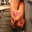 Pixelated image of two hands clasped together with a pink heart symbol on the left hand, blue text reading 'chada' at bottom right.