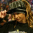 A pixelated static image shows a figure in dark clothing holding an object with warm tones against a blurred background.