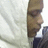 Pixelated close-up of a person's face in profile, wearing dark clothing against a light background.