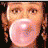 Pixelated static image of a person with light skin, brown eyes, and reddish-brown braided hair against dark background.