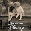 Two figures in light-colored clothing sit closely together on a bench, leaning toward each other with heads nearly touching, beneath stylized text reading "We're so Disney" in white script.
