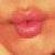 Pixelated close-up of lips with pinkish-red coloration against a warm-toned background, showing subtle shading and texture.