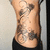 A pixelated close-up of a person's torso showing multiple tattoos on the chest and abdomen against a light background.