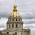 A pixelated image of a large domed building with a spire, set against a cloudy sky.