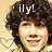 Pixelated image of a person with voluminous dark curly hair, light skin tone, and visible facial features including eyes, nose, mouth, and teeth. White text 'ily!' appears above the head on a beige background.