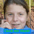 Pixelated image of a person with brown hair holding a phone to their ear, wearing a blue top, with a blue banner displaying green text at the bottom.