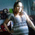 A person in a gray tank top stands with hands on hips against a cluttered background, showing slight variations in pose and lighting across frames.