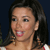 A pixelated close-up of a person with dark hair, light skin, and a smiling expression against a dark background.