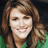 Pixelated static image of a person with brown hair and green clothing against dark background.