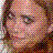 Pixelated close-up of a person's face with brown hair, pinkish skin tones, and visible eye details in muted colors.
