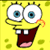 Yellow sponge character with large blue eyes, wide open mouth showing two front teeth and pink tongue, wearing white shirt, brown pants, red tie, pointing left on light blue background.