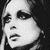 Black-and-white pixelated close-up of a person's face with dark hair, showing eyes, nose, and mouth in high-contrast grayscale tones.