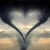 Animated heart-shaped icons with gradient fill transition between light and dark tones against a cloudy sky background.