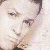 Pixelated close-up of a person's face with light skin tone, dark hair, and visible eyes and nose against a light background.