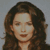 Static 50x50 pixel icon showing a close-up of a person with long brown hair against a gray background, rendered in low-resolution pixel art style.