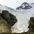 Pixelated static image showing a landscape with dark rock formations against a light sky with a single cloud, rendered in low-resolution digital style.