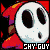 Pixelated character with white skull-like face, large black eyes, and red hooded cloak in