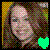 Pixelated image of a person with light skin and dark hair against a multicolored background, featuring a bright green heart shape in the bottom right corner.