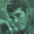 Pixelated green-toned image of a stylized face with dark hair and light skin, set against a mottled green background.