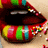 A pixelated close-up of a stylized mouth with glossy red lips, black interior, and colorful segmented teeth in yellow, green, blue, and white.