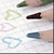 A static image shows a hand drawing hearts with colored pencils on paper, with text reading "Dont Forget..." and colored stripes below.
