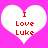 Two white heart shapes on a bright pink background, each containing red pixelated text reading "I Love Luke".