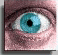 A pixelated close-up of a human eye with blue iris and black pupil, transitioning to the same eye closed with visible eyelashes.