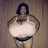 Pixelated image of a person with dark hair wearing a white top and dark shorts, standing against a muted brown background.