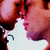 Two people in close proximity with lips touching, transitioning from a side profile to a frontal view