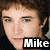 A pixelated image of a person with brown hair and blue eyes, featuring text overlays and a pink graphic element.