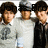 Six identical figures in gray shirts and black ties stand side-by-side, with the rightmost figure's face partially obscured by pixelated text.
