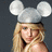 A pixelated image of a person with blonde hair wearing silver mouse ears, set against a dark background and bright pink border.