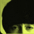 Pixelated close-up of a dark figure with yellow border, showing partial face and eye details.