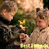 Two children with light brown hair stand close together outdoors, one holding a yellow flower, with 'Best Friends' text at the bottom.