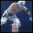 Pixelated figure in dynamic pose with extended limbs against dark blue background, rendered in light and brown tones.