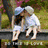 Two children in light blue clothing sit on a ledge, one leaning forward with hands near the ground while the other leans back; text "THE END OF LOVE" appears below them.