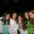 Group of people in a pixelated image with some wearing white, blue, and green clothing against dark background.