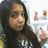 A pixelated image shows a person with long dark hair wearing a black top, extending their right hand toward the viewer.