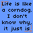 Blue background with black pixelated text repeating 'Life is like a corndog. I don't know why, it just is.' and orange star-like symbols.